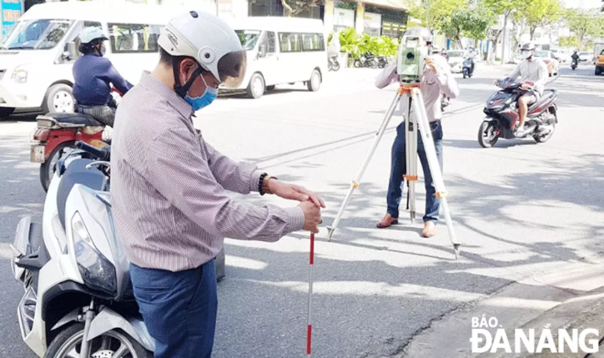 Các chuyên viên thuộc Sở Tài nguyên và Môi trường đang trắc địa tại khu vực tuyến đường Tiểu La (quận Hải Châu) vào ngày 7-1-2022. Ảnh: HOÀNG HIỆP